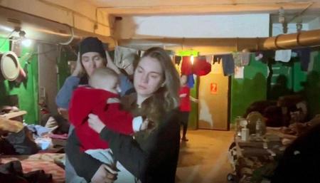 　１８日に公開された、ウクライナ・マリウポリの製鉄所内とされる避難場所にいる女性や子どもら（アゾフ連隊提供・ロイター＝共同）