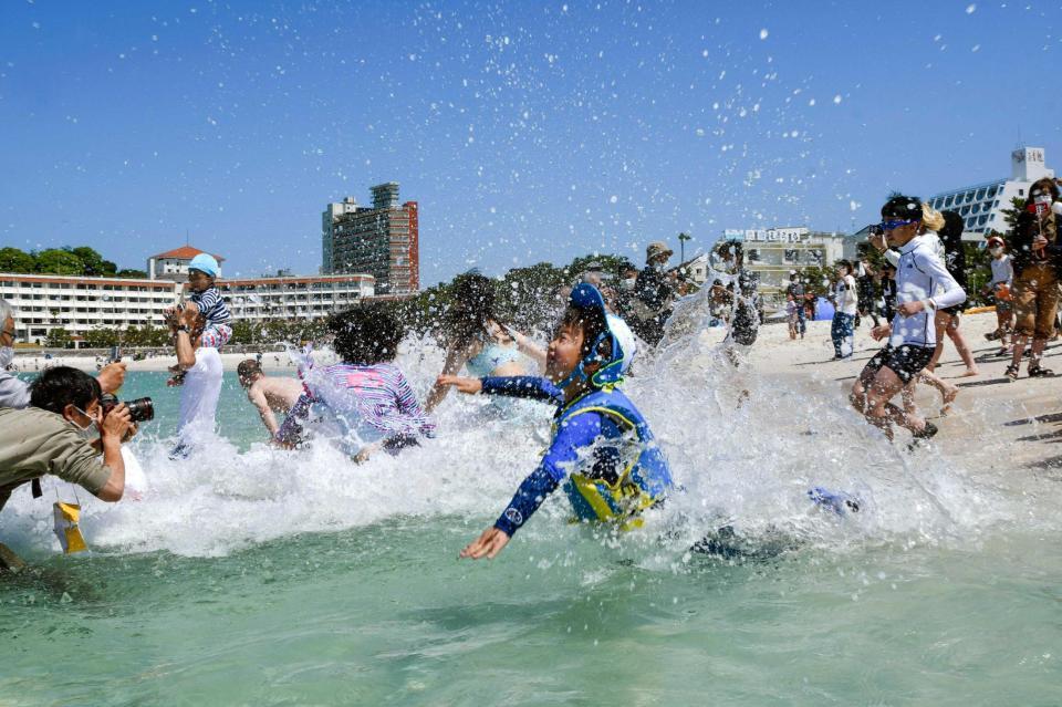 　和歌山県白浜町の白良浜で海へ飛び込む海水浴客ら