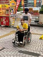長男の今井礼夢に車いすを押してもらう今井絵理子議員＝東京都内