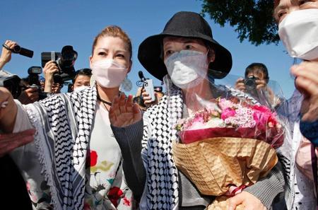 　医療刑務所を出所し、花束を手にする「日本赤軍」の重信房子元最高幹部。左は長女メイさん