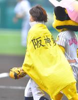 　「阪神愛」と書かれたマントを着て始球式に向かう有働由美子アナ（撮影・吉澤敬太）