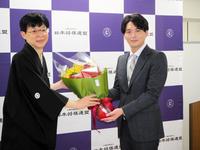 　弟子の都成竜馬七段から花束を受け取る谷川浩司十七世名人＝東京・将棋会館