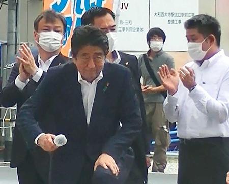 　８日、奈良市で街頭演説に臨む安倍元首相（手前）と山上徹也容疑者（右から２人目）