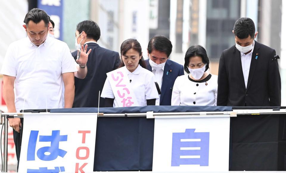 　喪章を着けて演説前に黙とうする生稲晃子氏（中央）