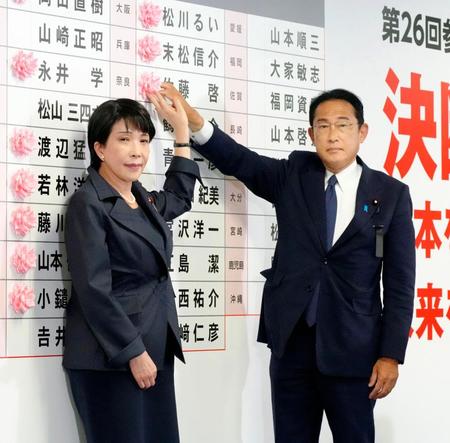 　開票センターで当確者の名前に花を付ける自民党総裁の岸田首相（右）と高市政調会長