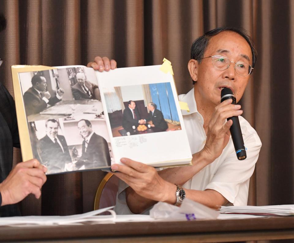 　「統一教会四十年史」に掲載された岸信介首相と統一教会・文鮮明教祖の写真を見せながら、説明をする山口広弁護士（撮影・伊藤笙子）