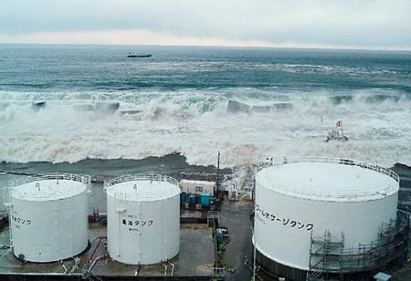 　東京電力福島第１原発５号機近くで撮影された津波。防波堤を破壊しタンクに迫る様子が確認できる＝２０１１年３月１１日（東京電力提供）