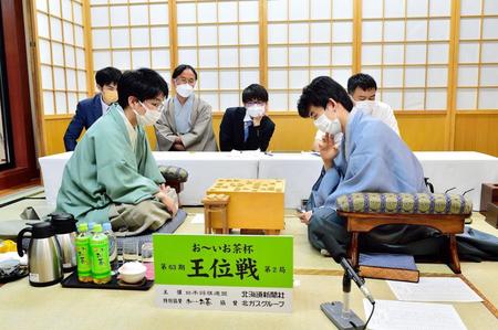 　豊島将之九段（左手前）に勝利した藤井聡太王位（右手前）＝日本将棋連盟提供