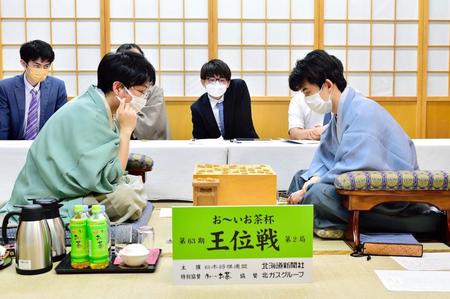 　豊島将之九段（左手前）に勝利した藤井聡太王位（右手前）＝日本将棋連盟提供