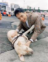 　盲導犬育成キャンペーンで犬とふれ合う山本コウタローさん＝１９９１年１０月
