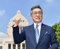 　国会議事堂を背にガッツポーズで気合を入れる日本維新の会・中条きよし参院議員