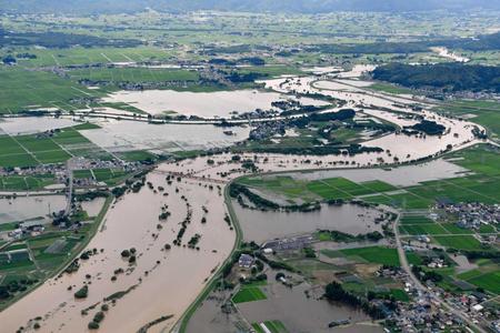 　大雨の影響で増水した、山形県の南陽市（右側）と川西町を流れる最上川（共同通信社機から）