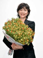 　紅花のドライフラワーを手に笑顔を見せる今井美樹