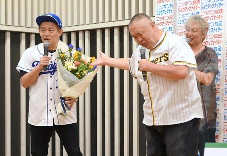 　松村邦洋（右）から花束を受け取るスピードワゴン・井戸田潤（撮影・堀内翔）