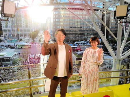 ファンをバックに手を振る福山雅治（左）と柴咲コウ＝福岡県・ＪＲ博多駅前広場