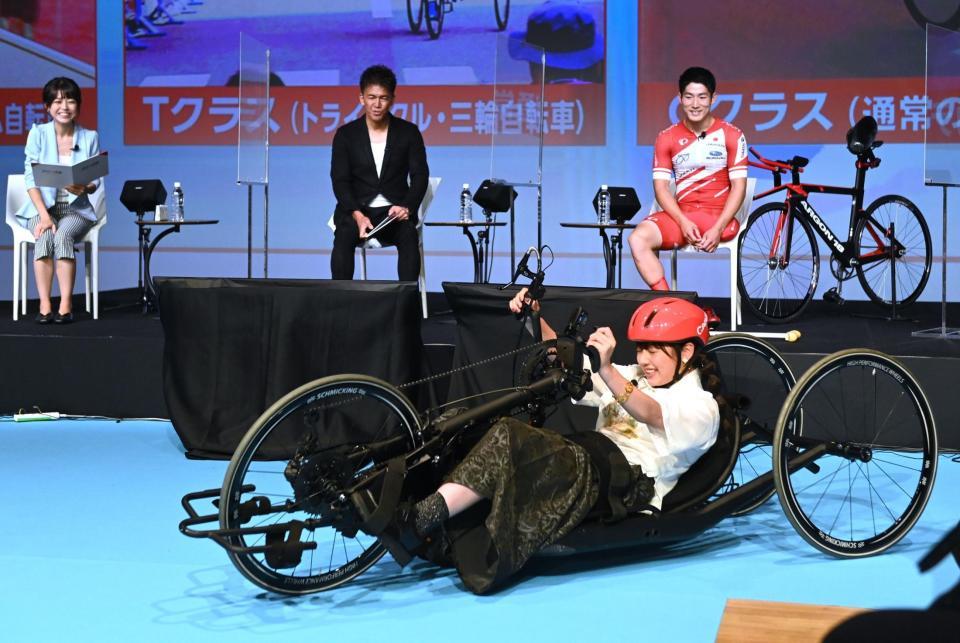 　武井壮（後列中央）らが見守る中、パラスポーツ用の手こぎ自転車に挑戦する渡邉美穂（撮影・高石航平）
