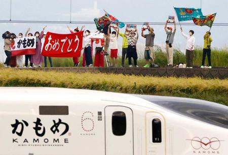 　旗や横断幕を手に、西九州新幹線開業を歓迎する人たち