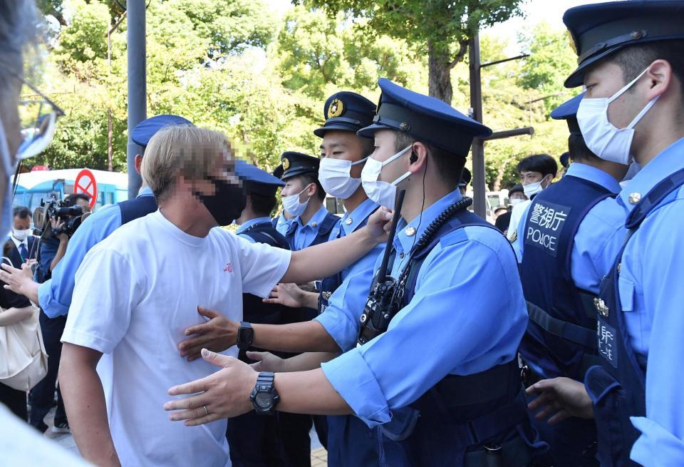 　言い争いになり、警官に止められる通行人