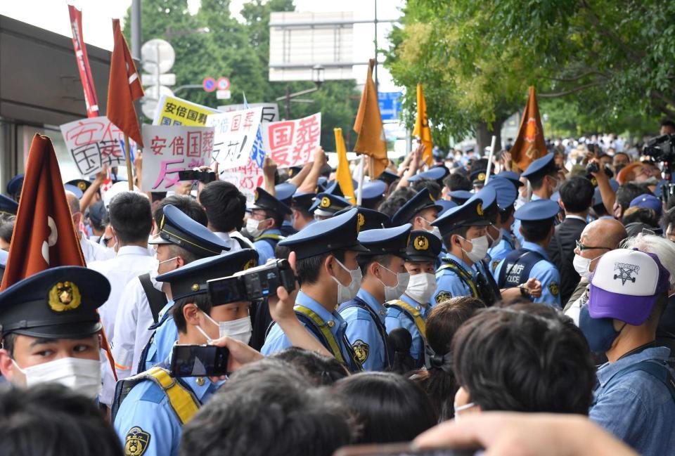 　国葬の反対派と賛成派が衝突し、間に入る警察官