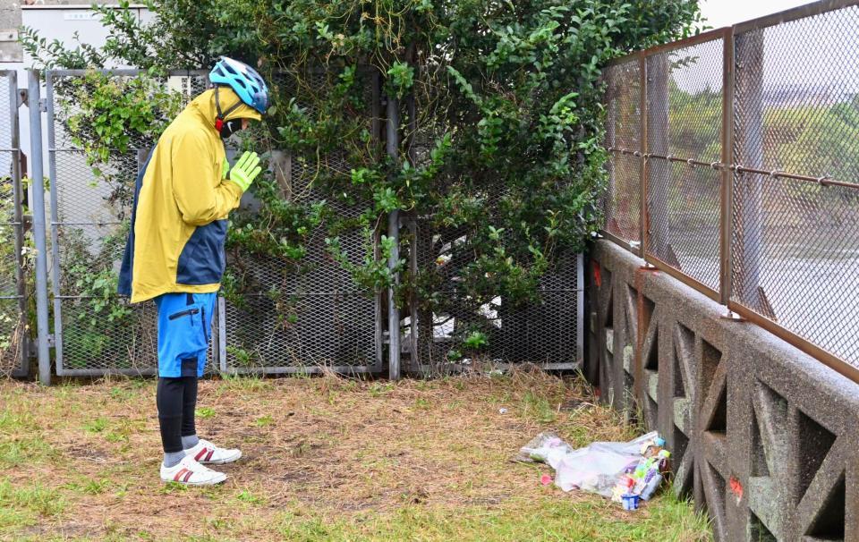 　行方不明になっていた南朝芽さんの遺体が見つかった旧江戸川に向かって手を合わせる男性＝千葉県市川市