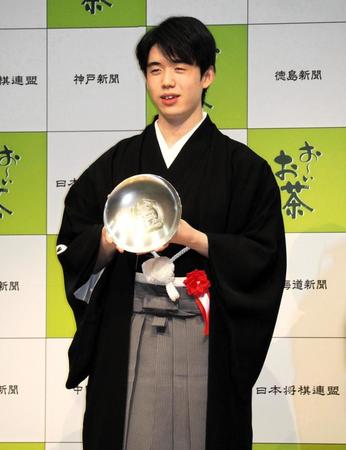 　王位杯を手に笑顔を見せる藤井聡太王位＝都内