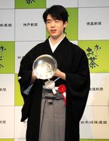 　王位杯を手に笑顔を見せる藤井聡太王位＝都内