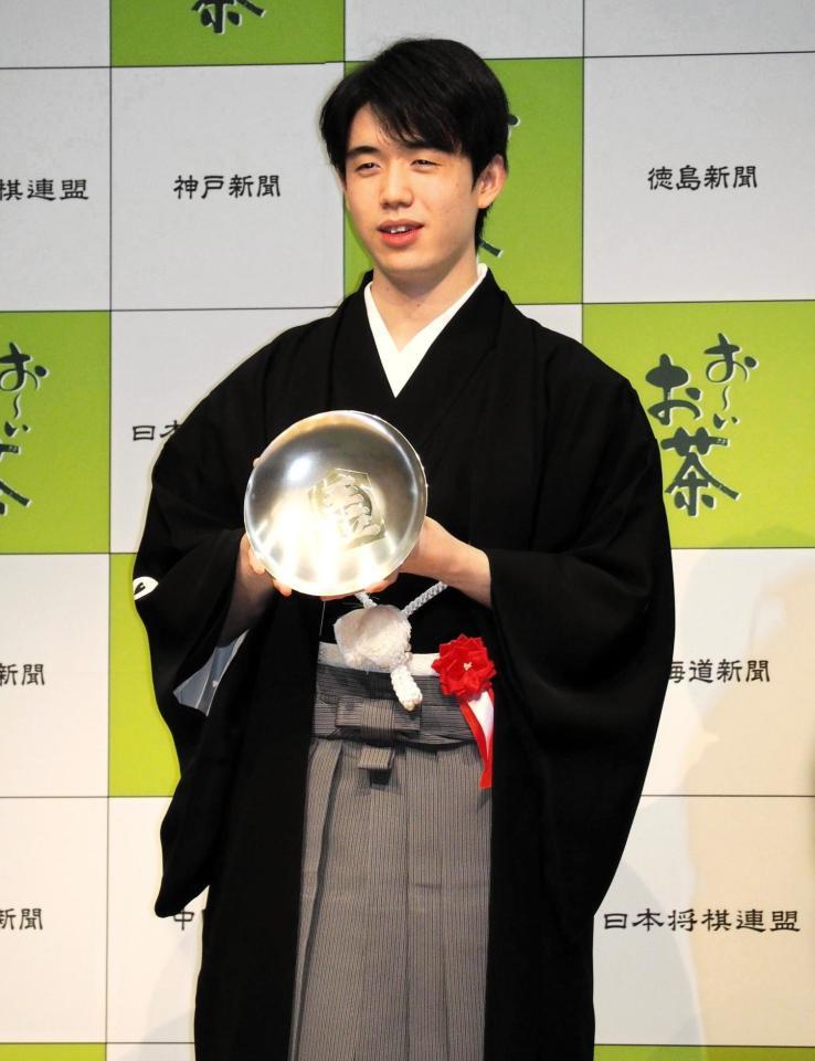 　王位杯を手に笑顔を見せる藤井聡太王位＝都内