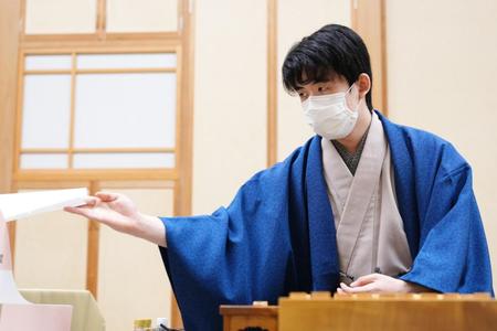 　第３５期竜王戦七番勝負第３局で、封じ手を待つ間、棋譜用紙を受け取る藤井聡太竜王＝代表撮影