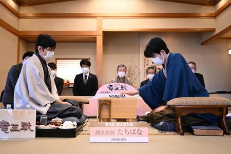 　第３５期竜王戦七番勝負第３局で、２手目を指す藤井聡太竜王（右）と広瀬章人八段＝代表撮影