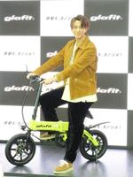 　コンパクト電動バイクにまたがって笑顔の三浦翔平