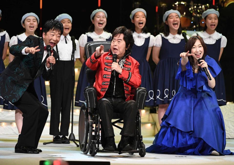 　車いすに乗り「マジンガーＺ」を熱唱する水木一郎。左は合田道人、右は森口博子
