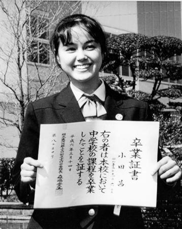 　中学校の卒業証書を手に笑顔をみせる小田茜＝１９９４年３月