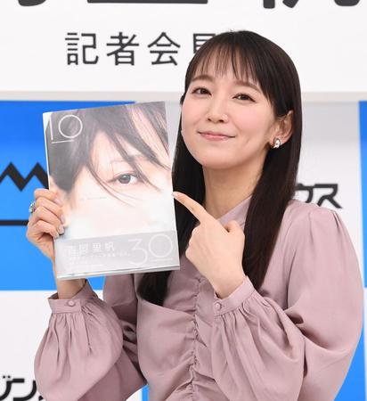 　出来上がったＷアニバーサリー写真集を指さす吉岡里帆（撮影・園田高夫）