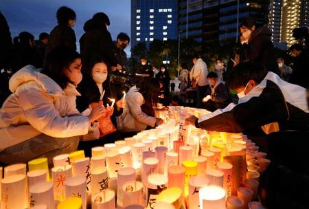 　阪神・淡路大震災の犠牲者を追悼し灯籠に火をともす人たち