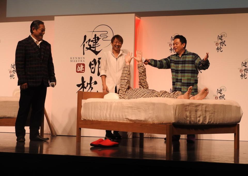 　枕を使ったユースケ（中央）の変化をアピールする津田篤宏（右、左は松平健）