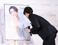 　自身のポスターにサインをする片寄涼太（撮影・園田高夫）