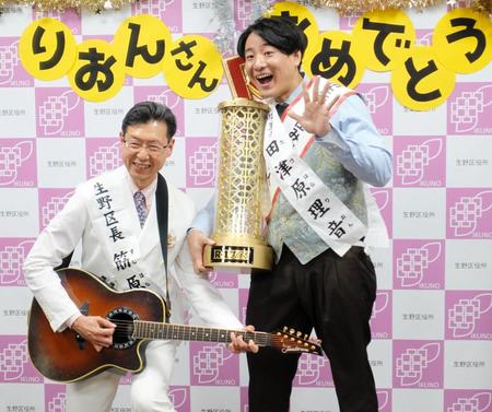 筋原章博生野区長（左）からオリジナルソングで祝福された田津原理音