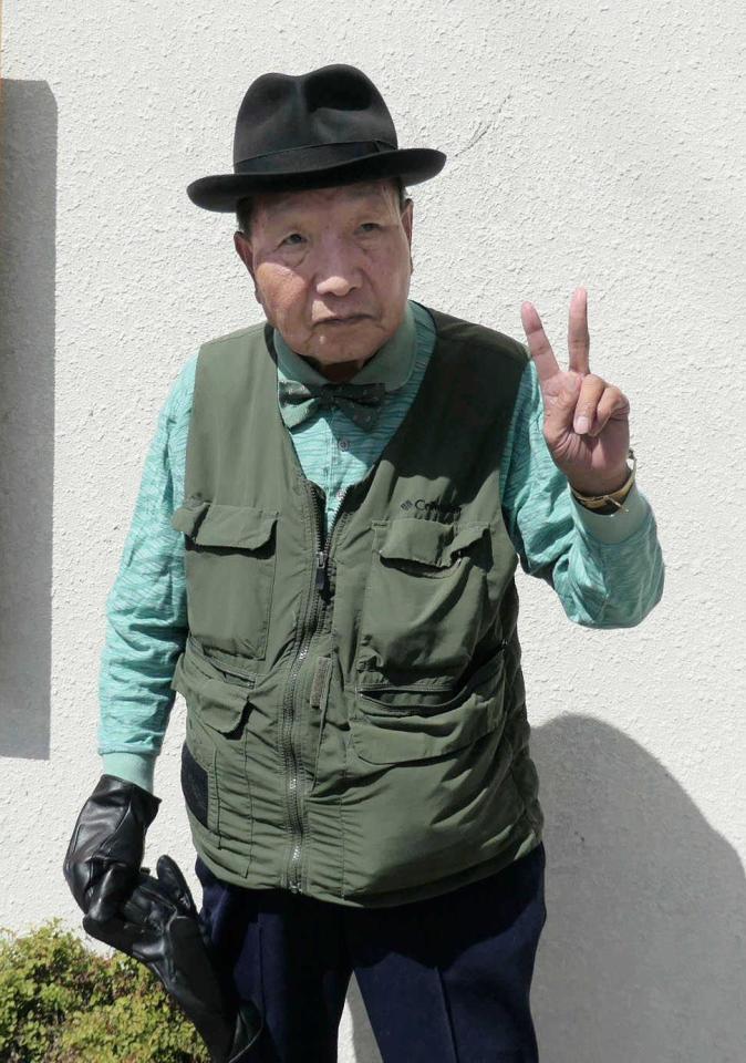 　日課の散歩のため自宅を出て、ピースサインをする袴田巌さん＝浜松市（袴田さん支援クラブ提供）