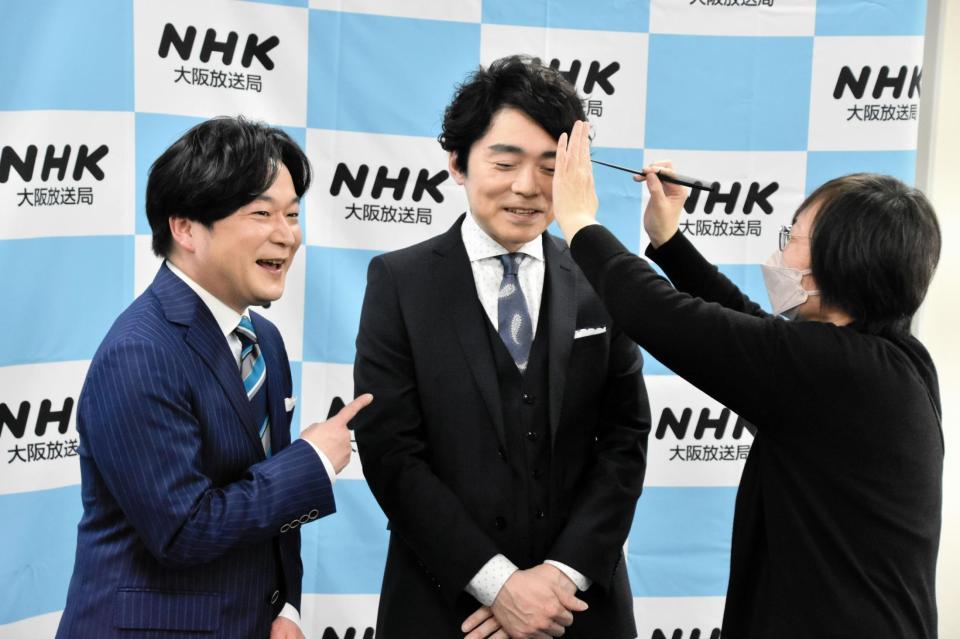 　写真撮影中、メーク担当者から髪形を直されるＮＨＫの高瀬耕造アナウンサー。左は小山径アナウンサー