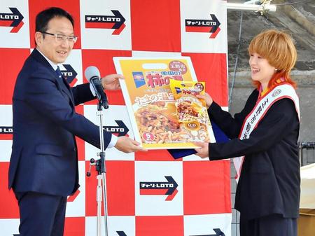 　柴田義朗玉野市長（左）から柿の種たまの温玉めし１年分を授与された尼神インター渚