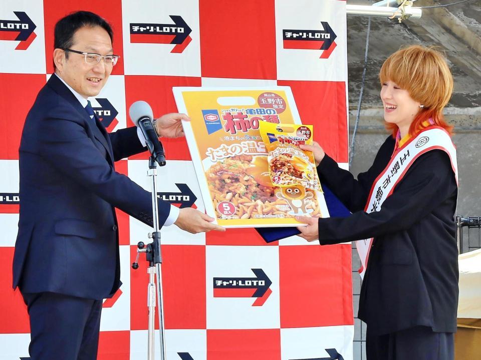 　柴田義朗玉野市長（左）から柿の種たまの温玉めし１年分を授与された尼神インター渚