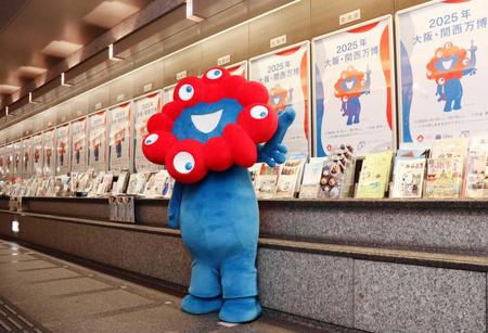 　張り出されたポスターを披露する「ミャクミャク」