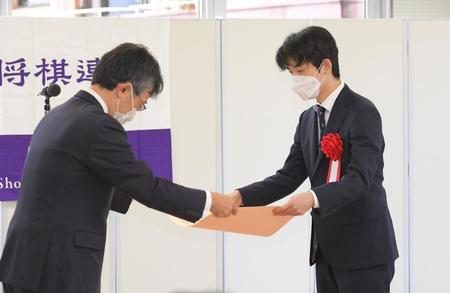 　最優秀棋士賞に輝き、日本将棋連盟・佐藤康光会長（左）から賞状を授与される藤井聡太竜王（撮影・佐藤厚）