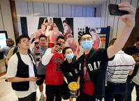 　公開を前に、映画館で記念写真に納まる人たち＝１９日、上海市（共同）