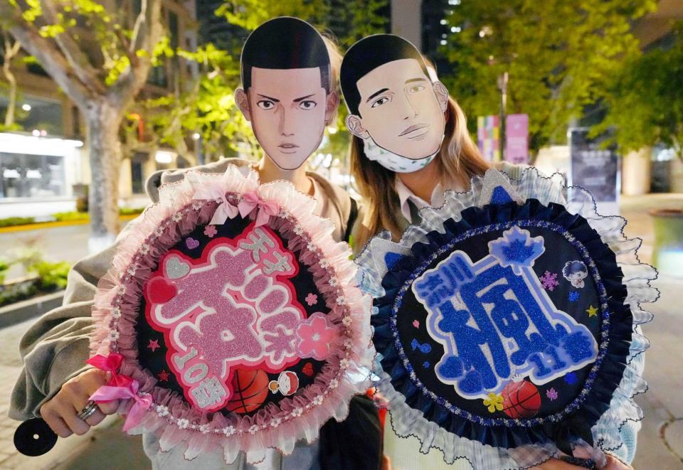 　登場キャラクターのお面を着けてポーズをとる人たち＝上海市（共同）