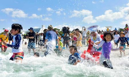 　和歌山県白浜町の白良浜で海へ飛び込む海水浴客ら