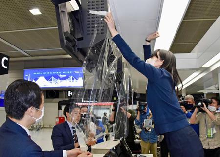 　飛沫防止のフィルムを撤去する成田国際空港会社の職員