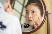 鏡をのぞきこむ寿恵子（浜辺美波）