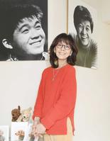 　坂本九さんの写真の前で笑顔を見せる