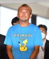 　青いＴシャツ姿で連行されるガーシー容疑者